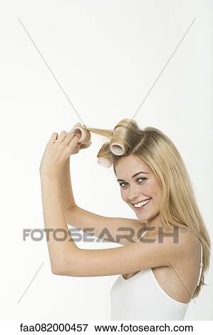Teen girl rolling her hair with curlers View Large Photo Image Stock Photo - Teen girl rolling her hair with curlers. Fotosearch