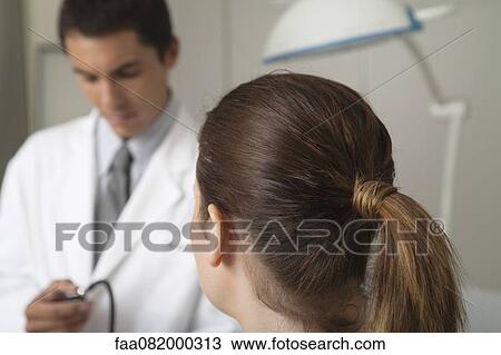Woman getting blood pressure taken in doctor's office, rear view View Large Photo Image Stock Image - Woman getting blood pressure taken in doctor's office, rear view. Fotosearch