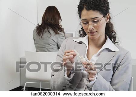 Woman painting her fingernails at work View Large Photo Image Picture - Woman painting her fingernails at work. Fotosearch