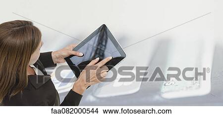 Woman using digital tablet, image of wallet containing credit cards superimposed on background View Large Photo Image Picture - Woman using digital tablet, image of wallet containing credit cards superimposed on background. Fotosearch