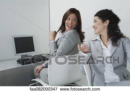 Stock Photo - Women chatting together in office. Fotosearch