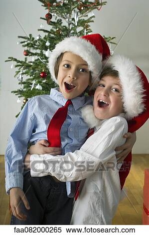 Young friends wearing Santa hats and embracing on Christmas View Large Photo Image Stock Photography - Young friends wearing Santa hats and embracing on Christmas. Fotosearch