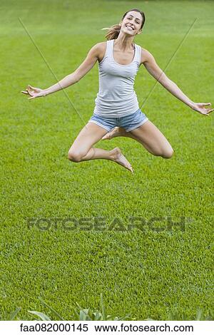 Young woman jumping in air in yoga position View Large Photo Image Stock Photography - Young woman jumping in air in yoga position. Fotosearch