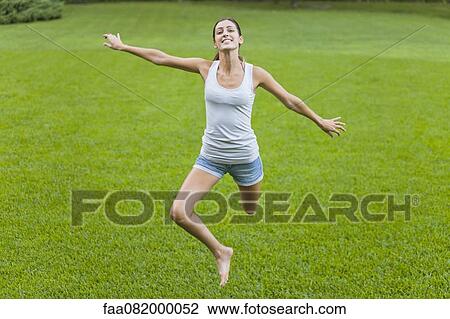 Young woman jumping in air View Large Photo Image Stock Image - Young woman jumping in air. Fotosearch