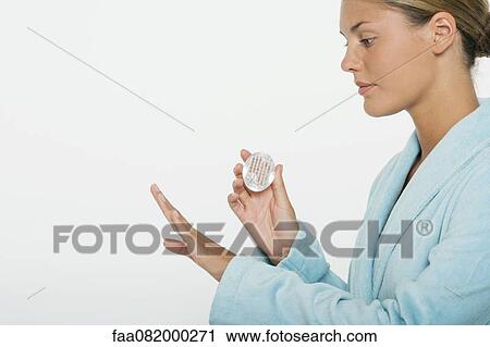 Young woman using nail brush, side view View Large Photo Image Stock Image - Young woman using nail brush, side view. Fotosearch