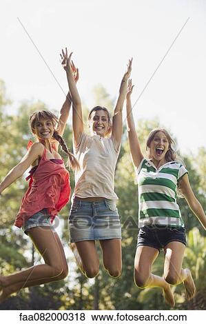 Young women jumping in air, smiling View Large Photo Image Stock Photo - Young women jumping in air, smiling. Fotosearch