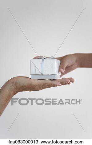 Stock Image - Boy handing woman present, cropped. Fotosearch