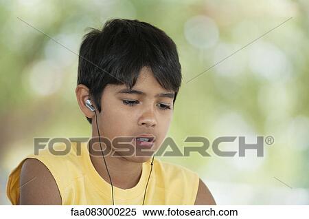 Stock Photography - Boy listening to earphones. Fotosearch