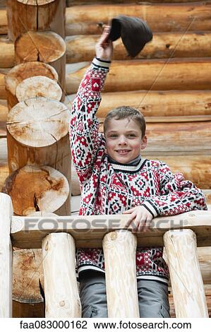 Boy standing on deck of log cabin, waving hat at camera, portrait View Large Photo Image Stock Image - Boy standing on deck of log cabin, waving hat at camera, portrait. Fotosearch
