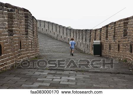 Stock Image - Boy walking on Great Wall of China, China. Fotosearch