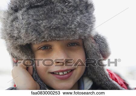 Stock Image - Boy wearing trappers hat, portrait, close-up. Fotosearch