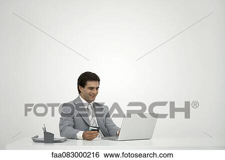 Stock Photograph - Businessman shopping online with credit card. Fotosearch
