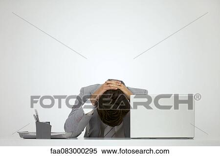 Businessman sitting at desk with head down View Large Photo Image Stock Photography - Businessman sitting at desk with head down. Fotosearch