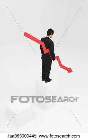 Businessman standing at top of steps holding arrow pointed downward View Large Photo Image Stock Photography - Businessman standing at top of steps holding arrow pointed downward. Fotosearch