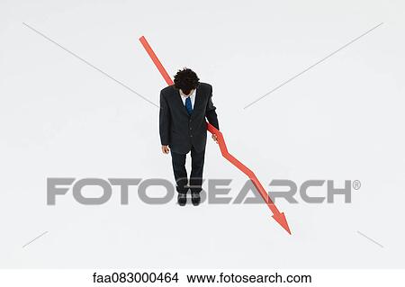 Businessman with arrow pointed downward, projecting financial loss View Large Photo Image Picture - Businessman with arrow pointed downward, projecting financial loss. Fotosearch