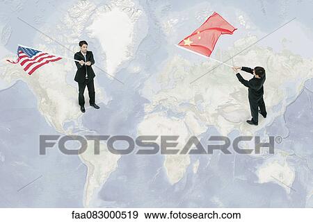 Stock Photo - Businessmen standing on world map, waving American and Chinese flags. Fotosearch