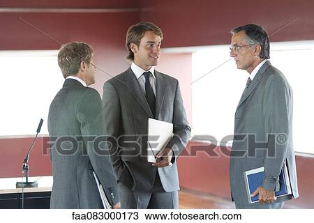 Businessmen talking in office View Large Photo Image Stock Image - Businessmen talking in office. Fotosearch