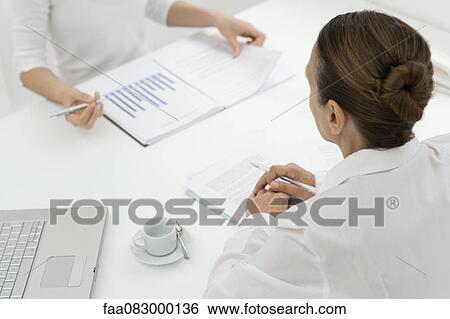 Stock Photograph - Businesswomen in meeting, cropped. Fotosearch