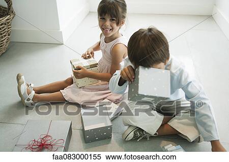 Children Sitting On Floor Opening Gifts Stock Photography