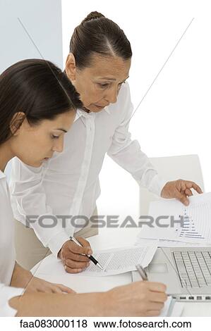 Stock Photo - Colleagues discussing documents. Fotosearch
