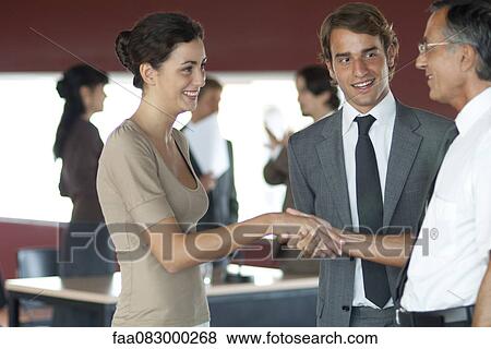 Colleagues shaking hands in office View Large Photo Image Stock Photo - Colleagues shaking hands in office. Fotosearch