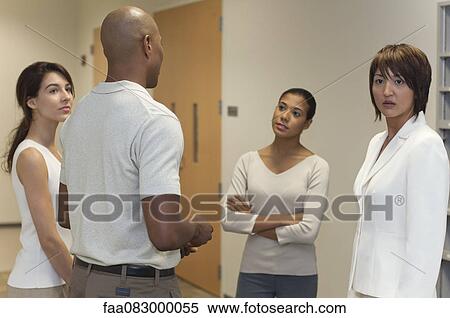 Colleagues talking in office View Large Photo Image Stock Photography - Colleagues talking in office. Fotosearch