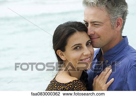 Couple embracing at the beach, portrait View Large Photo Image Stock Image - Couple embracing at the beach, portrait. Fotosearch