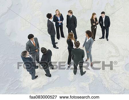 Stock Photo - Executives chatting while standing on map of Europe. Fotosearch