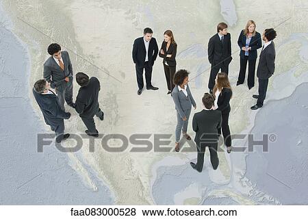 Stock Photo - Executives chatting while standing on map of the United States. Fotosearch