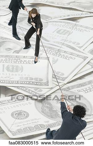 Executives playing tug-of-war on top of pile of one-hundred dollar bills View Large Photo Image Stock Photography - Executives playing tug-of-war on top of pile of one-hundred dollar bills. Fotosearch
