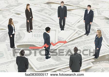 Executives standing on large pile of money around man holding arrow forecasting financial future View Large Photo Image Stock Photo - Executives standing on large pile of money around man holding arrow forecasting financial future. Fotosearch