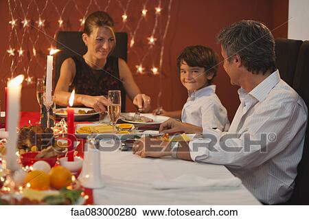 Stock Image - Family having Christmas dinner. Fotosearch