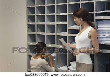 Female office workers filing documents View Large Photo Image Stock Photograph - Female office workers filing documents. Fotosearch