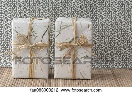 Gifts wrapped in paper and raffia View Large Photo Image Stock Image - Gifts wrapped in paper and raffia. Fotosearch