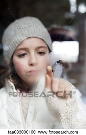 Girl drawing on fogged glass View Large Photo Image Stock Image - Girl drawing on fogged glass. Fotosearch