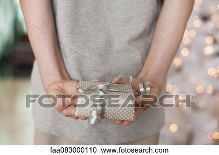 Girl holding gift behind back View Large Photo Image Stock Image - Girl holding gift behind back. Fotosearch