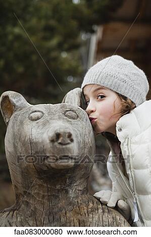 Girl kissing bear statue, portrait View Large Photo Image Stock Image - Girl kissing bear statue, portrait. Fotosearch