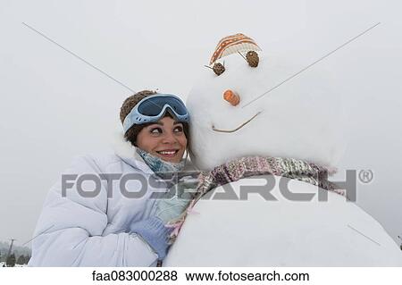 Girl leaning against snowman, portrait View Large Photo Image Stock Photo - Girl leaning against snowman, portrait. Fotosearch