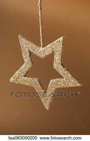 Stock Image - Golden star shaped Christmas ornament. Fotosearch