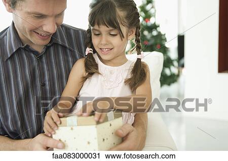 Little girl opening Christmas present with father View Large Photo Image Stock Image - Little girl opening Christmas present with father. Fotosearch