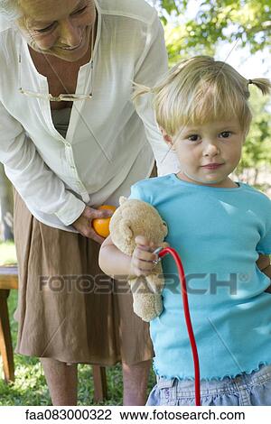 Stock Image - Little girl outdoors with grandmother, portrait. Fotosearch
