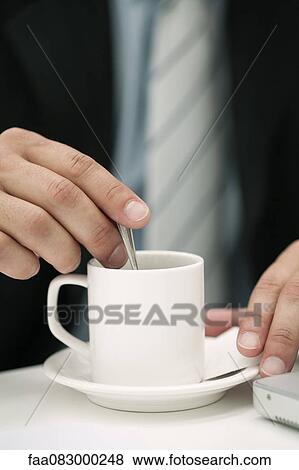 Man stirring cup of coffee, cropped View Large Photo Image Stock Photo - Man stirring cup of coffee, cropped. Fotosearch
