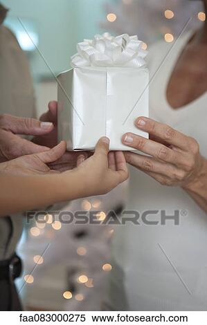 Man, woman and child's hands holding gift together, cropped View Large Photo Image Stock Photography - Man, woman and child's hands holding gift together, cropped. Fotosearch