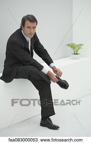 Mature businessman tying shoelace View Large Photo Image Stock Image - Mature businessman tying shoelace. Fotosearch