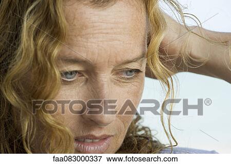 Mature woman looking down in thought View Large Photo Image Stock Photo - Mature woman looking down in thought. Fotosearch