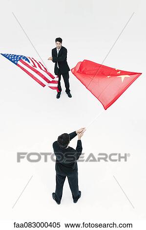 Stock Photography - Men standing face to face, waving Chinese and American flags. Fotosearch