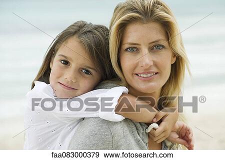 Mother and daughter embracing at the beach, portrait View Large Photo Image Stock Photo - Mother and daughter embracing at the beach, portrait. Fotosearch