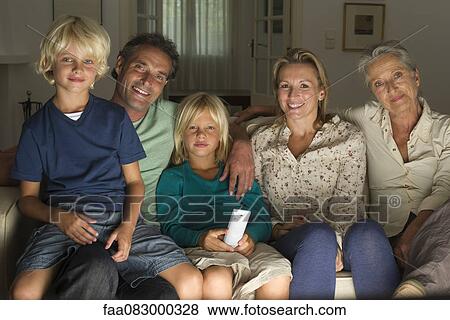 Stock Photo - Multi-generation family watching TV together, portrait. Fotosearch