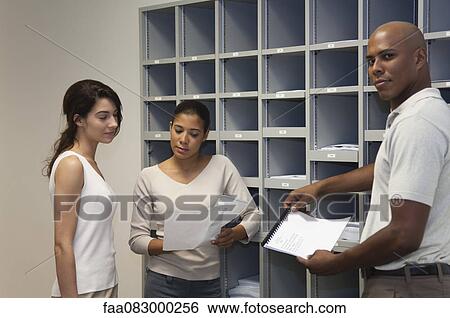 Stock Photograph - Office workers discussing documents. Fotosearch