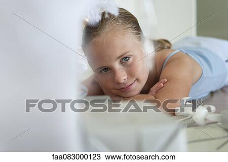 Preteen girl lying on floor next to gifts View Large Photo Image Stock Image - Preteen girl lying on floor next to gifts. Fotosearch